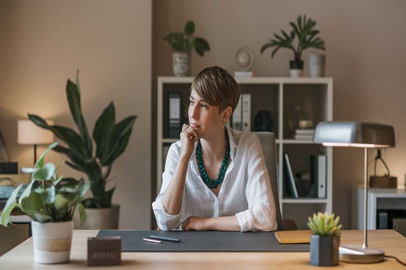 A professional sitting quietly at a desk after a challenging conversation.