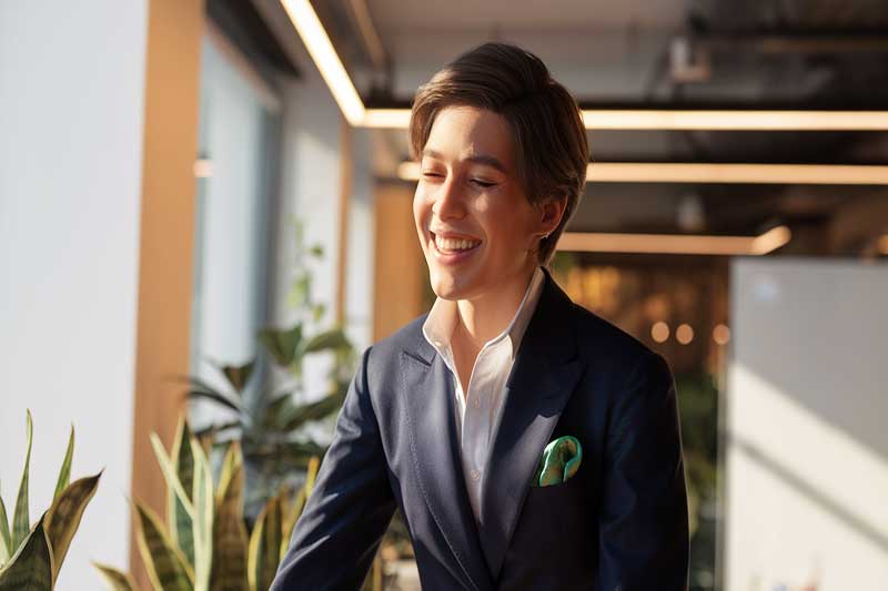 A relieved professional standing near a window after a successful conversation